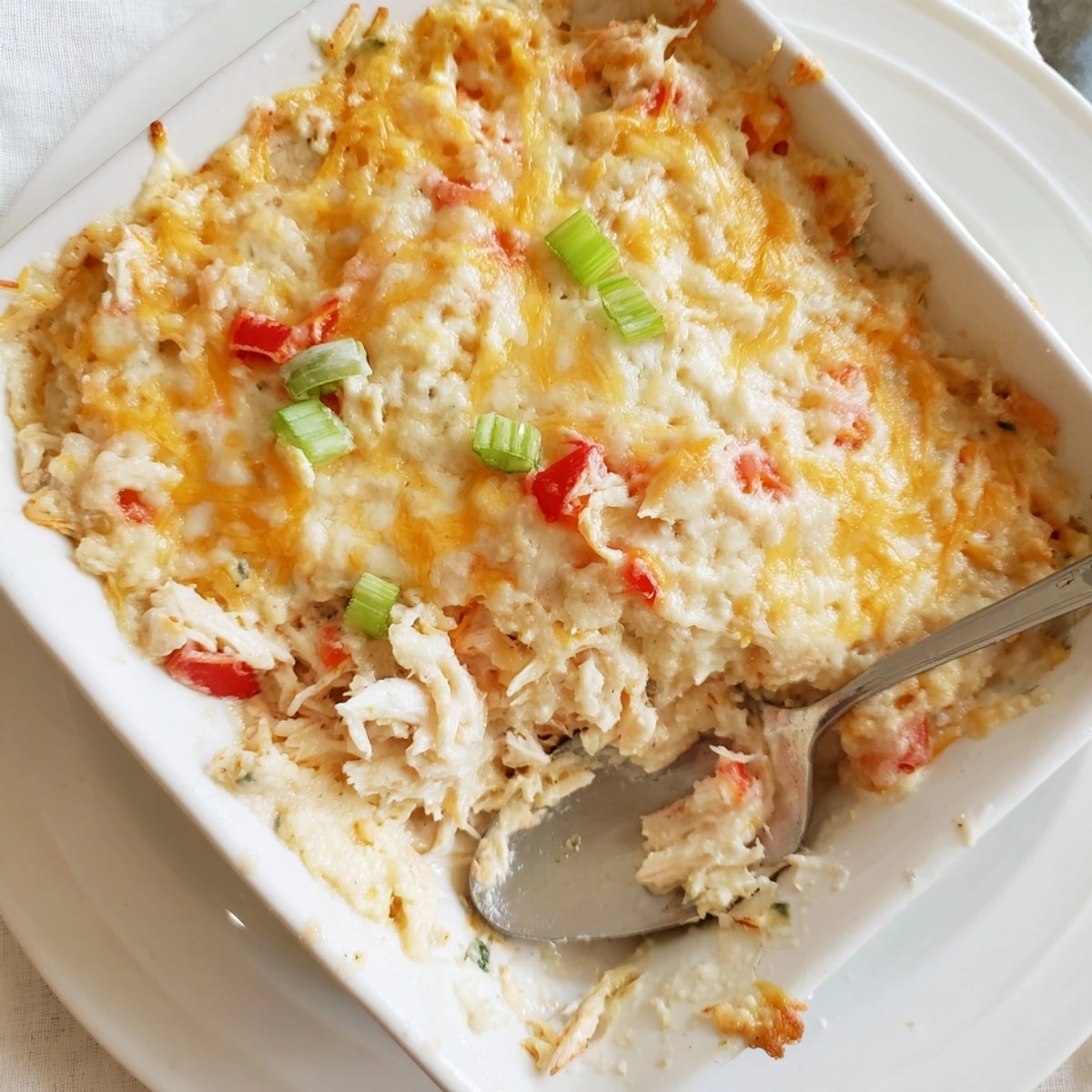 Scoopable Cheesy Cajun Crab Dip, studded with sweet crab and peppers, ready for dipping.