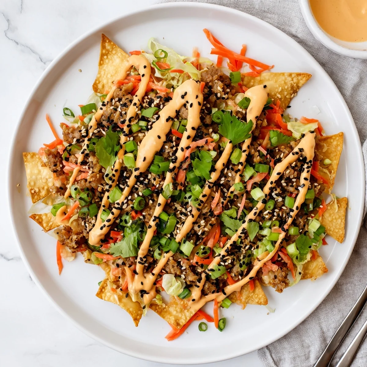 Crispy Japanese Gyoza Nachos topped with spicy sriracha mayo drizzles for flavor.  