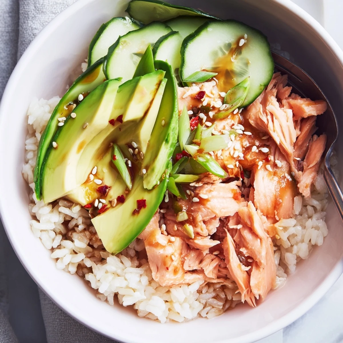 Flavorful Leftover Salmon & Rice Bowl garnished with sesame seeds and scallions.  