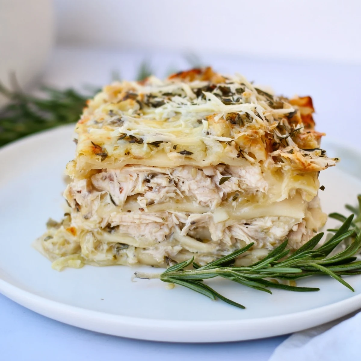 This homemade Rosemary Chicken Lasagna features layers of savory chicken, creamy sauce, and cheesy goodness.