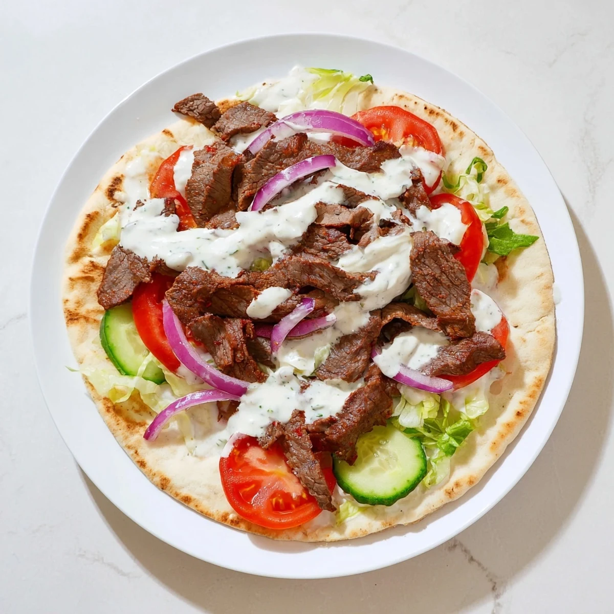 Juicy beef shawarma wraps, filled with vibrant veggies and drizzled with a creamy yogurt sauce.