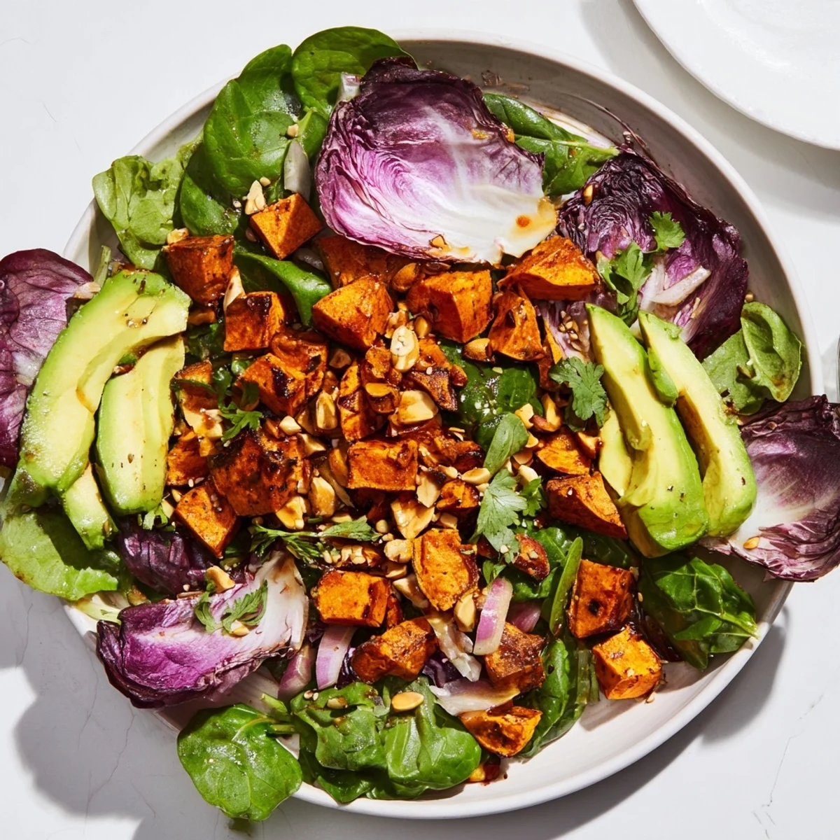 A colorful Spiced Peanut Sweet Potato & Radicchio Salad Bowl shows off the nutty dressing drizzled over fresh ingredients.