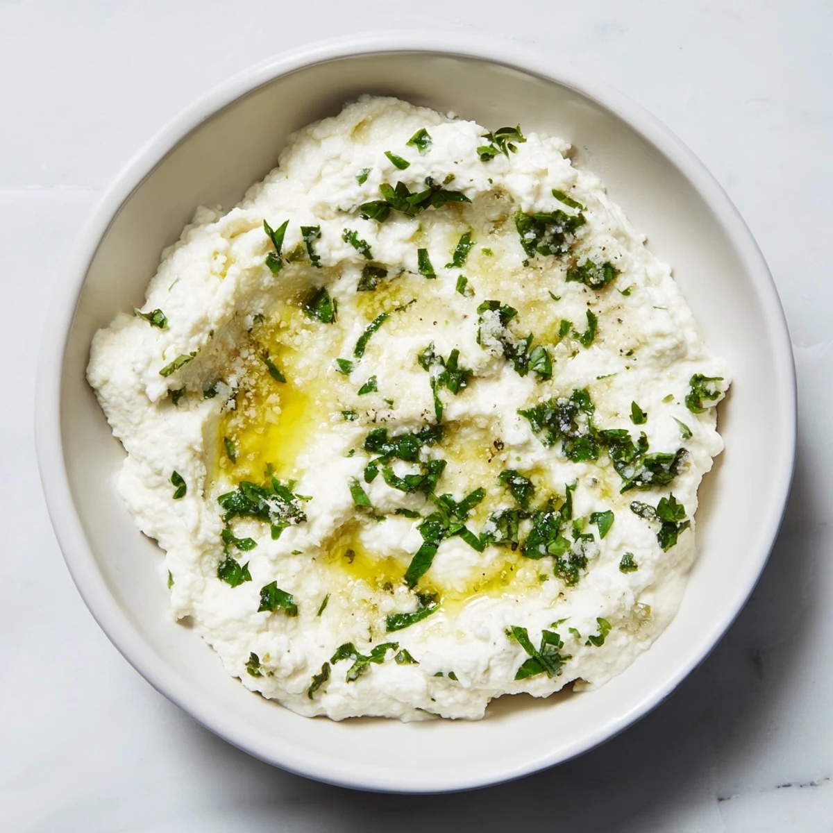 Creamy whipped feta dip with lemon-mint drizzle, ideal for dipping warm pita bread.
