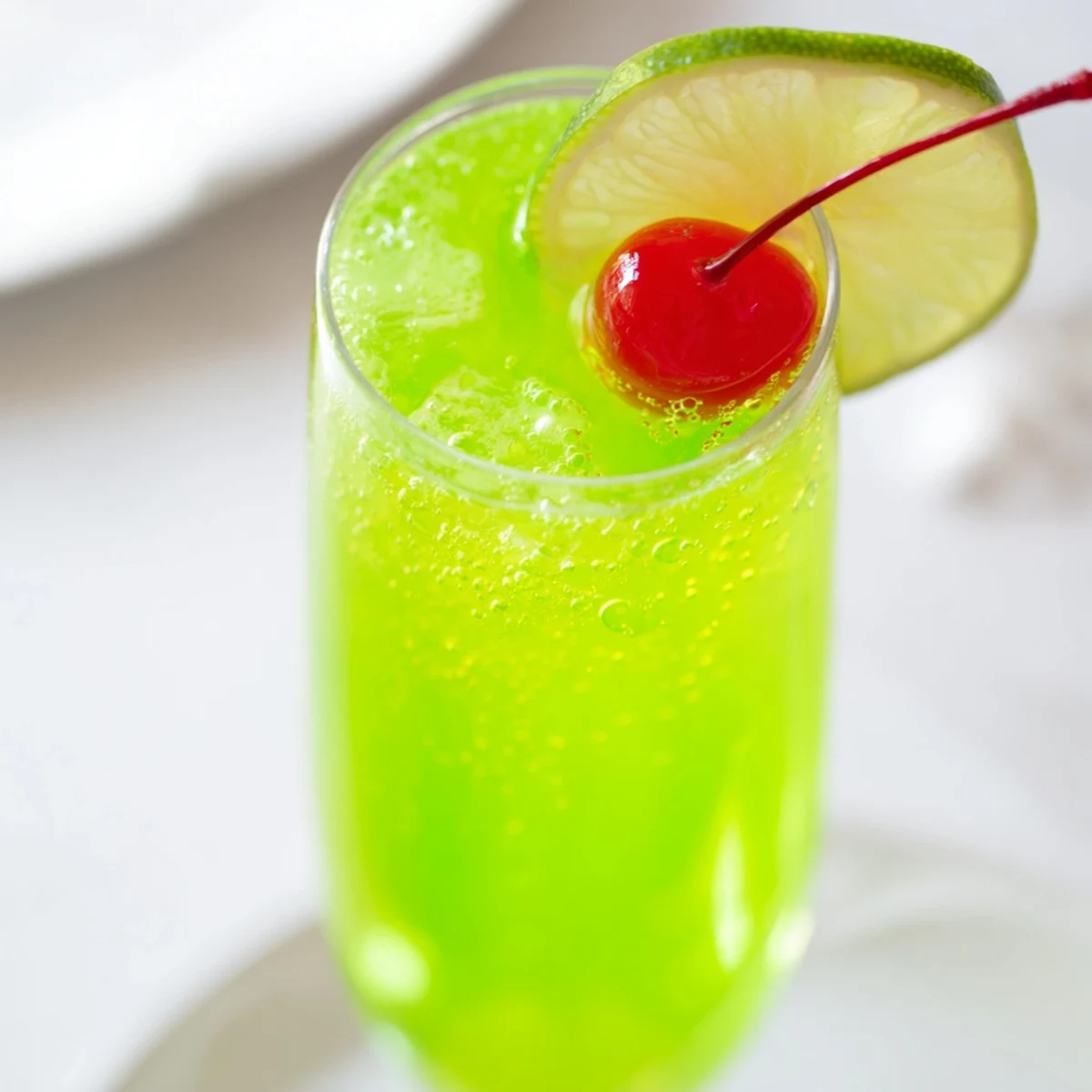 Delicious Quick Grinch Mimosa Mocktail ready to serve, with lime garnish, perfect mocktail for celebrations.