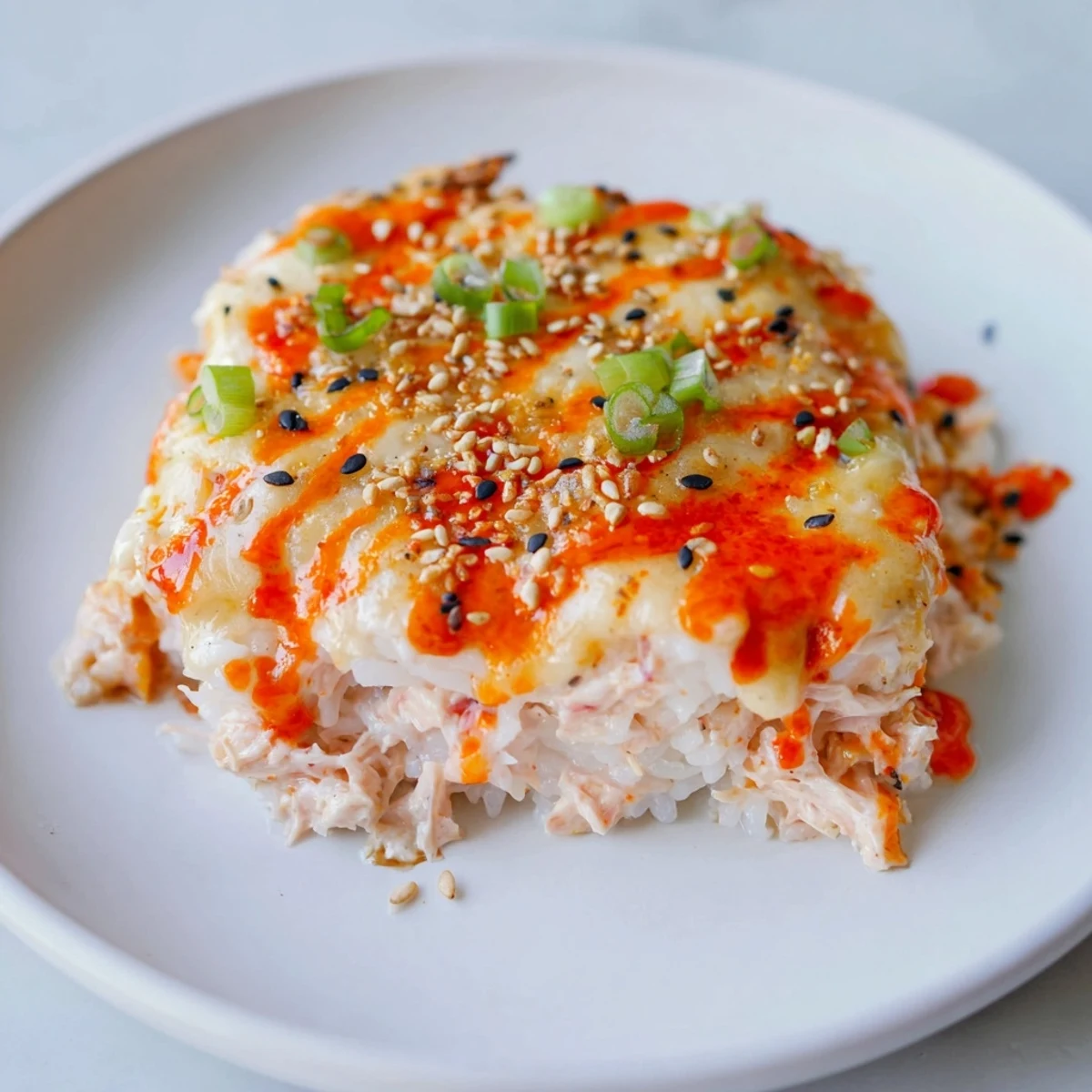 Creamy Salmon Sushi Bake topped with melted cheese, glistening and ready to serve with nori.