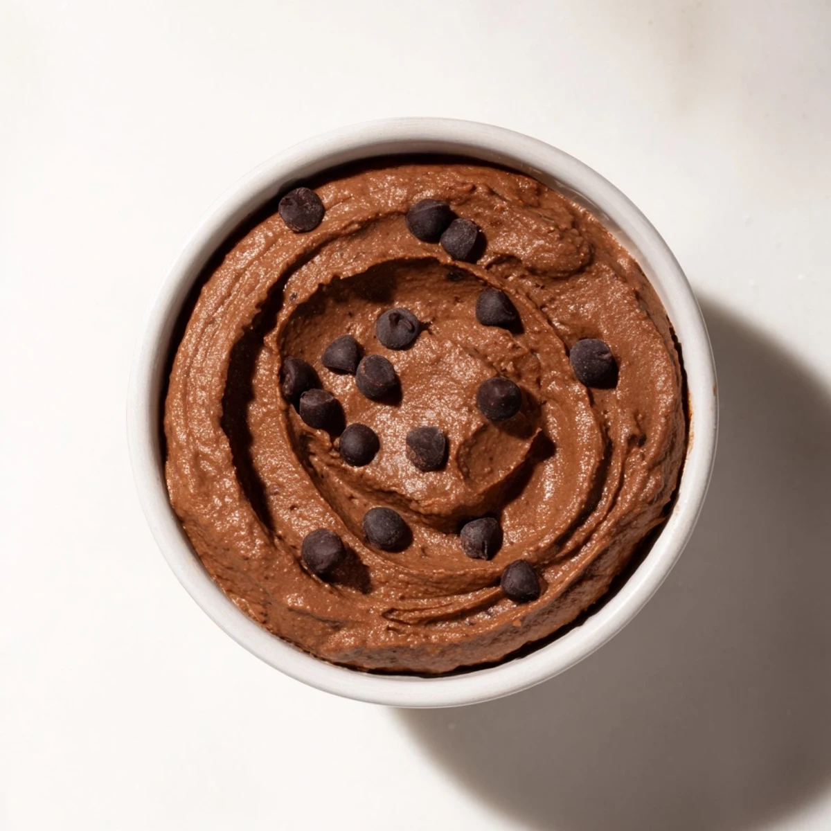 Rich, dark chocolate hummus in a serving bowl, ready to be enjoyed with gluten-free crackers.