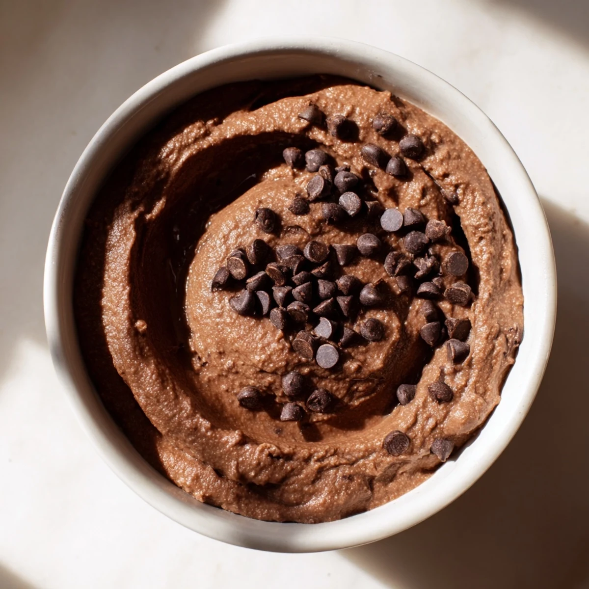 Homemade chocolate hummus, a smooth, vegan dessert dip with optional chocolate chips included.