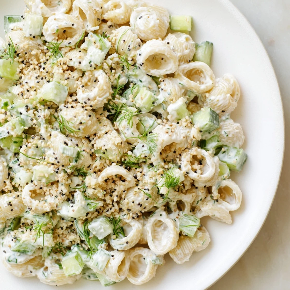 Creamy Cucumber Crunch Pasta Salad with tiny shell pasta, crisp diced cucumbers, fresh dill, and a sprinkle of everything bagel seasoning, served chilled.