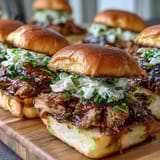 Smoky slow-cooked pulled pork with creamy coleslaw on slider buns, perfect for festive gatherings and baby shower spreads.  
