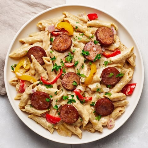 Steaming bowl of Smoked Sausage Cajun Alfredo with penne, rich sauce coating tender pasta and sausage.