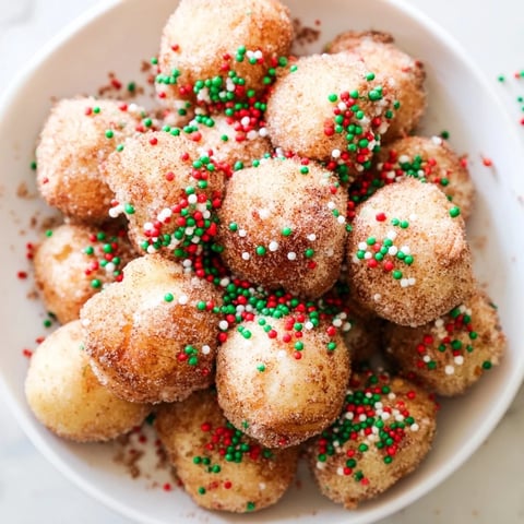 Golden brown air fryer Christmas donut holes, glistening with butter and sprinkled with festive joy.