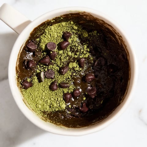 Fudgy Matcha Peppermint Brownie Batter Mug Cake, a quick dessert with chocolate chips, ready to eat.