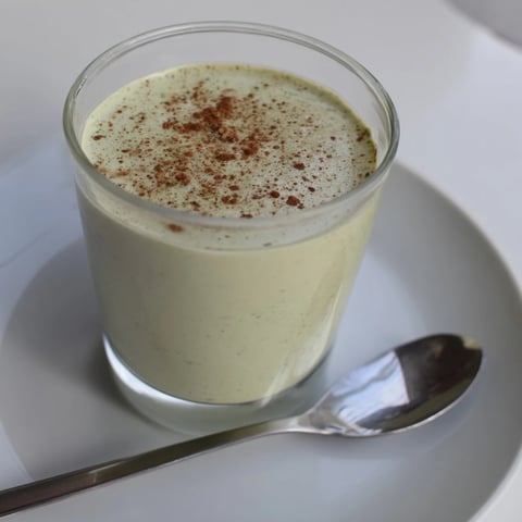 A vibrant green Matcha Eggnog Collagen Breakfast Smoothie, swirled in a tall glass, ready to enjoy.