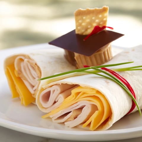 Savory Graduation Cap Diploma Snack Wraps featuring rolled wraps and chocolate-topped cracker hats.