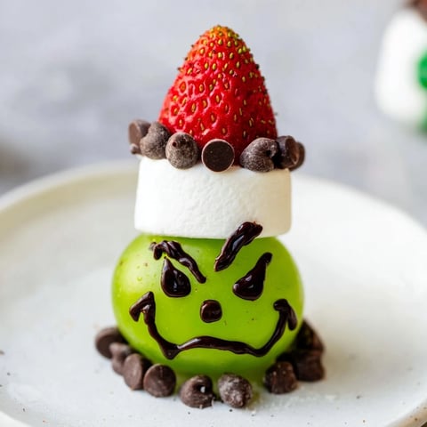 Grinch Snack recipe: whimsical green grape faces with marshmallow hats, perfect for festive treats.
