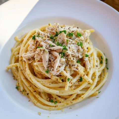 Golden garlic butter coats the bucatini pasta with tender chicken, a simple, delicious meal.