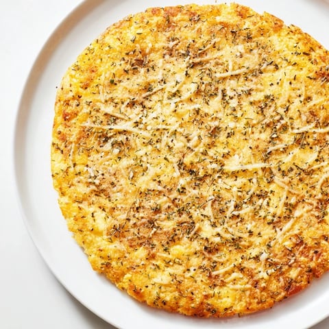 Golden-brown cauliflower pizza crust, ready for toppings, promising a delicious low-carb pizza night.
