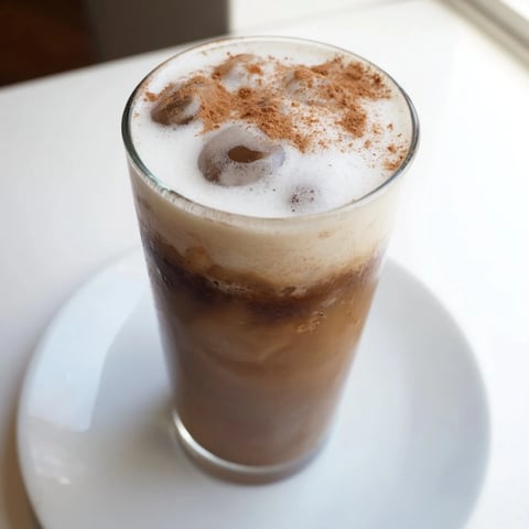 A chilled Iced Brown Sugar Oat Latte, its creamy texture visible, swirled with brown sugar.