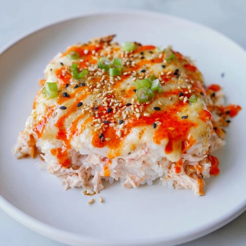 Creamy Salmon Sushi Bake topped with melted cheese, glistening and ready to serve with nori.