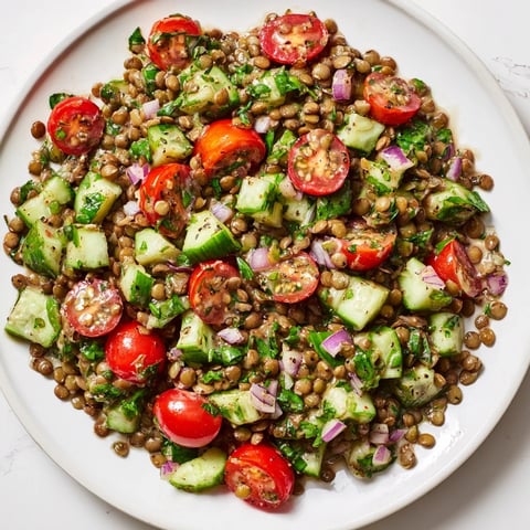 Hearty lentil salad overflowing with juicy tomatoes and cucumbers, tossed in a tangy mustard vinaigrette.