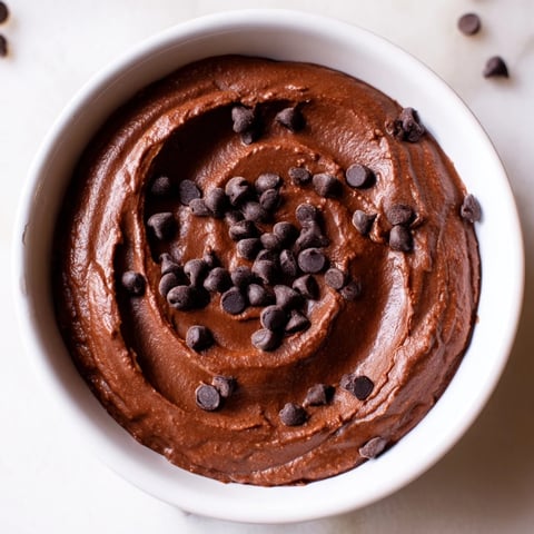 A swirl of creamy chocolate hummus, perfect for dipping fresh strawberries for snacking.