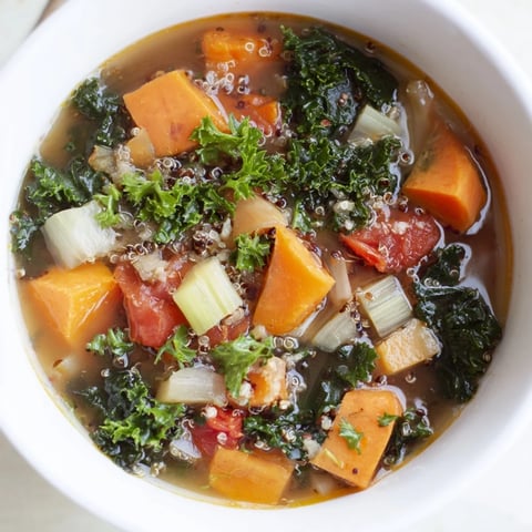 A steaming bowl of Nourishing Winter Veggie Soup, with colorful vegetables and fluffy quinoa.