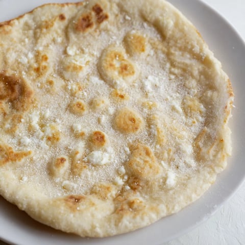 Golden cottage cheese flatbread, pan-fried to perfection, ready to be enjoyed with a dipping sauce.