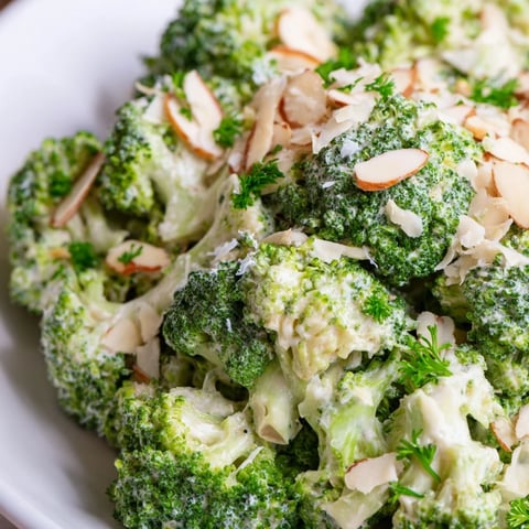 Bright green broccoli florets tossed in creamy garlic-Parmesan dressing, topped with toasted almonds and fresh parsley.