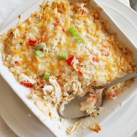 Scoopable Cheesy Cajun Crab Dip, studded with sweet crab and peppers, ready for dipping.