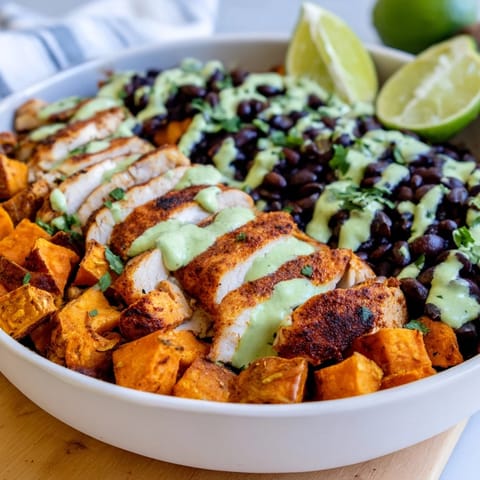 Indulge in this hearty Chipotle Chicken Bowl, topped with creamy cilantro lime sauce.  
