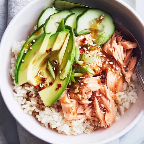Flavorful Leftover Salmon & Rice Bowl garnished with sesame seeds and scallions.  