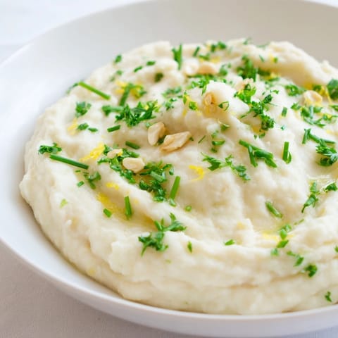 Fluffy cauliflower mash, light and airy, served with fresh herbs for a comforting dinner.
