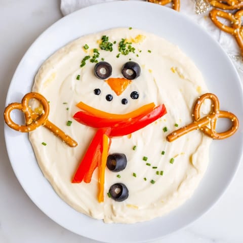 Creamy Melted Snowman Dip Bowl, ready to scoop with crackers, a festive party snack.