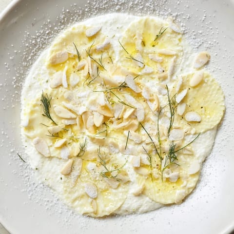 Detailed view of the Snowy Pinecone Centerpiece: a holiday appetizer with almond "scales" and snowy dusting.