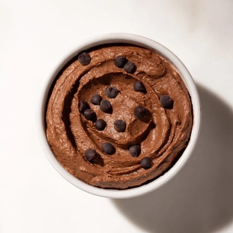 Rich, dark chocolate hummus in a serving bowl, ready to be enjoyed with gluten-free crackers.