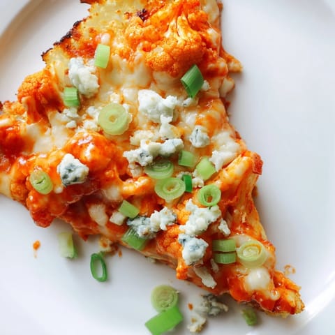 Buffet Cauliflower Pizza ready to serve, featuring a golden-baked crust, bubbly cheese, and a side of crisp celery sticks for dipping.