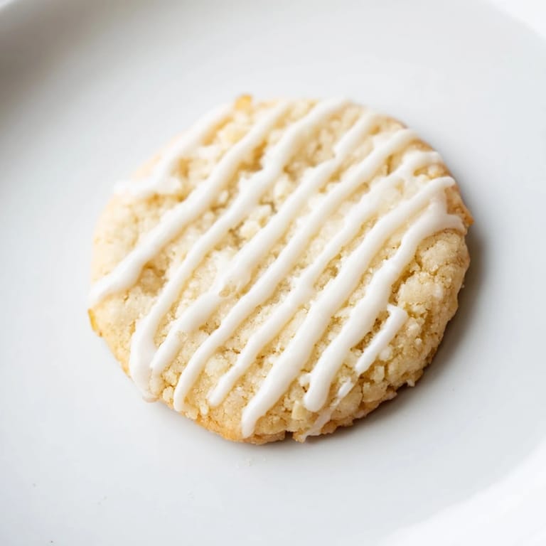 Buttery Holiday Cookies with Icing Drizzle, freshly baked with a sweet vanilla icing, perfect for sharing.
