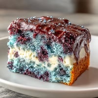 Galaxy Graduation Cake with Edible Stars shines in a marbled swirl of black, navy blue, purple, pink, and teal buttercream, topped with shimmering gold and silver stars.